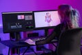 Creative digital artist editing video at work in modern office space