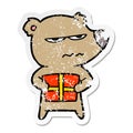 A creative distressed sticker of a angry bear cartoon holding present