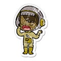 A creative distressed sticker of a cartoon astronaut girl yawning