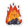 A creative distressed sticker of a cartoon blazing coal fire