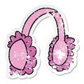 A creative distressed sticker cartoon doodle of pink ear muff warmers