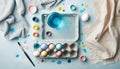 Creative Easter background with eggs, paint, brushes, egg carton and linen cloth. Flat lay on light blue background. Created with Royalty Free Stock Photo