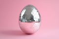 A creative Easter celebration concept featuring a disco ball egg on a pink background with copy space Royalty Free Stock Photo