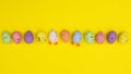 Creative Easter colorful layout with eggs on vibrant yellow background. Flat lay spring concept