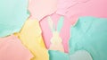 Creative Easter concept with cut-out bunny surrounded by torn edges of pastel soft-colored paper