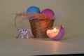 creative easter concept, vitnage small basket with colorful eggs next to toy rabbit and candle in eggshell, easter design Royalty Free Stock Photo
