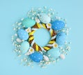 Creative Easter layout made of eggs and flowers on blue background. Circle wreath flat lay concept Royalty Free Stock Photo