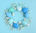 Creative Easter layout made of eggs and flowers on blue background. Circle wreath flat lay concept Royalty Free Stock Photo