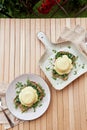 Creative eggs benedict with plant-based sauce, sourdough bread, tofu, young onion, greens, pea sprouts outside. Vegan Royalty Free Stock Photo