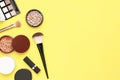 Creative Fashion background. Set of decorative cosmetics mascara powder lipstick eyeshadow blush makeup brush on yellow background Royalty Free Stock Photo