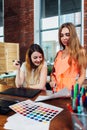 Creative female interior decorator working with a customer in her office choosing colors for a new design using color Royalty Free Stock Photo