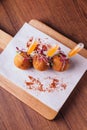 Creative fine dining: Chicken Biryani Srancini served in rice ball with sweet and spicy dip on wooden chop board Royalty Free Stock Photo