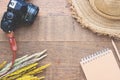 Creative flat lay of Autumn concept with dried flowers, camera, straw hat and notebook on wood