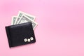 Creative flat lay business concept. Black wallet on a pink background with the word tax of wooden letters.