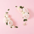 Creative flat lay with colorful flowers and green leaves on pastel pink background. Royalty Free Stock Photo