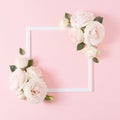 Creative flat lay with colorful flowers and white frame on pastel pink background. Royalty Free Stock Photo