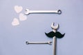 Creative flat lay overhead top view retro stylish black funny paper moustache, little hearts and combination wrenches