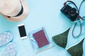 Creative flat lay of passport, camera and woman accessories on pastel color background