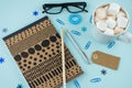 Creative flat lay photo of workspace desk with smartphone, eyeglasses, pen, pencil and notebook, minimal style on blue background. Royalty Free Stock Photo