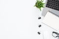 Creative flat lay photo of workspace desk. Top view office desk with laptop, glasses, notebook and plant on white color background