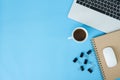 Creative flat lay photo of workspace desk. Top view office desk with laptop, notebooks and coffee cup on blue color background. Royalty Free Stock Photo