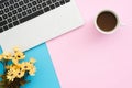 Creative flat lay photo of workspace desk. Top view office desk with laptop, plant and coffee cup on blue pink color background. Royalty Free Stock Photo