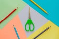 Creative flat lay with school suppllies. multicolored pencils and green scisors on pastel colorful background. Back to school