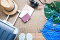 Creative flat lay summer vacation concept with suitcase, passport, camera and bikini on wooden background