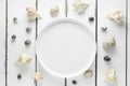 White plate with seashells on white wooding background, wallpaper top view Royalty Free Stock Photo