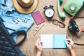 Creative flat lay of woman hands planning trip vacation with accessories