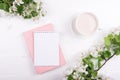 Creative flat lay of workspace desk, notepad and spring blossom