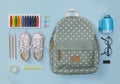 Creative flatlay of education blue table with backpack, shoes, colorful crayon, eye glasses, isolated on blue background, Concept Royalty Free Stock Photo