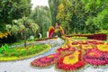 Creative flower design with a Firebird statue and multicolored flowerbeds in spring at flower show.