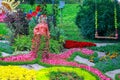 Creative flower design with a Forest Girl statue and multicolored flowerbeds in spring at flower show.