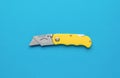 Creative folding knife for cutting on a blue background. Flat lay Royalty Free Stock Photo