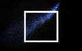 Creative frame concept with neon blue glitter splash trail on black background. Minimal flat lay design with star dust on dark Royalty Free Stock Photo