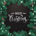 Creative frame made of Christmas fir branches. Silver Merry Christmas text on black wooden background Royalty Free Stock Photo