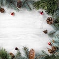 Creative frame made of Christmas fir branches on white wooden background with red decoration Royalty Free Stock Photo