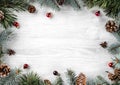 Creative frame made of Christmas fir branches on white wooden background with red decoration, pine cones. Xmas and New Year theme Royalty Free Stock Photo