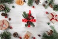 Creative frame made of Christmas fir branches on white wooden background with red decoration, pine cones. Xmas and New Year theme Royalty Free Stock Photo