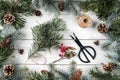 Creative frame made of Christmas tree branches and pine cones on white wooden background with scissors, fir branches Royalty Free Stock Photo