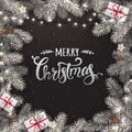 Creative frame made of snowy Christmas fir branches. Silver Merry Christmas text on black background Royalty Free Stock Photo