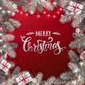Creative frame made of snowy Christmas fir branches. Silver Merry Christmas text on red background Royalty Free Stock Photo