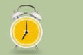 Creative fresh lime slice alarm clock on pastel green background