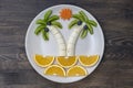 Creative fruit dessert with kiwi, banana, grape, carrot and orange. Concept children food. Fun food. Palm trees shape made from Royalty Free Stock Photo