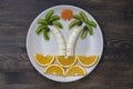 Creative fruit dessert with kiwi, banana, grape, carrot and orange. Concept children food. Fun food. Palm trees shape made from