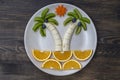 Creative fruit dessert with kiwi, banana, grape, carrot and orange. Concept children food. Fun food. Palm trees shape made from