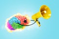 Creative fun smart brain explodes with fire, holds a yellow loudspeaker and screams on blue background. Brainstorm, concept. Royalty Free Stock Photo