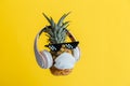 Creative funny pineapple face wearing glasses headphones and protective medical mask. Resting levitating pineapple face Royalty Free Stock Photo