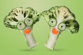 Creative funny vegetables. Broccoli and cucumber on a light green background